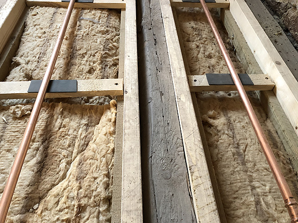 Badezimmer mit Holzbalkendecke und Janßen-Fußbodenheizung