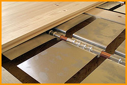 ::Dies ist die Janßen-Fußbodenheizung im Trockenaufbau. Das Heizsystem - die Heizrohre mit den aufgesteckten Aluminium-Wärmeverteilern - sind in die Hohlräume zwischen den Lagerhölzern integriert. aluminium-2040